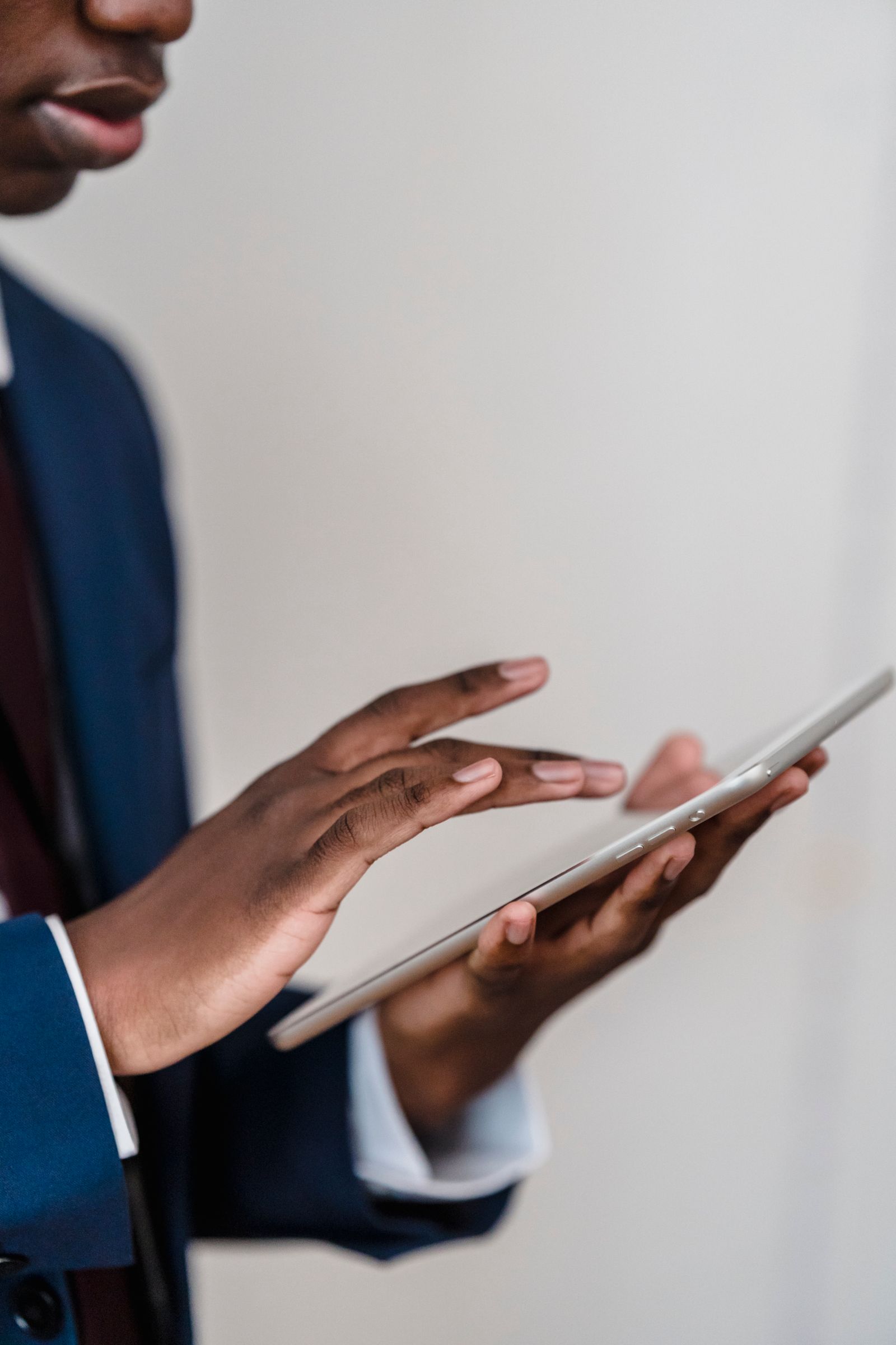 Close-up of a businessman&rsquo;s hands using a digital tablet indoors.